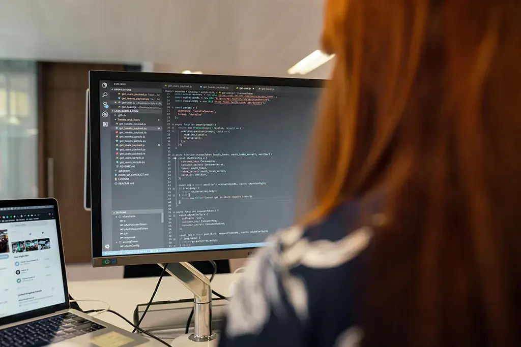 Developer working on code with multiple monitors